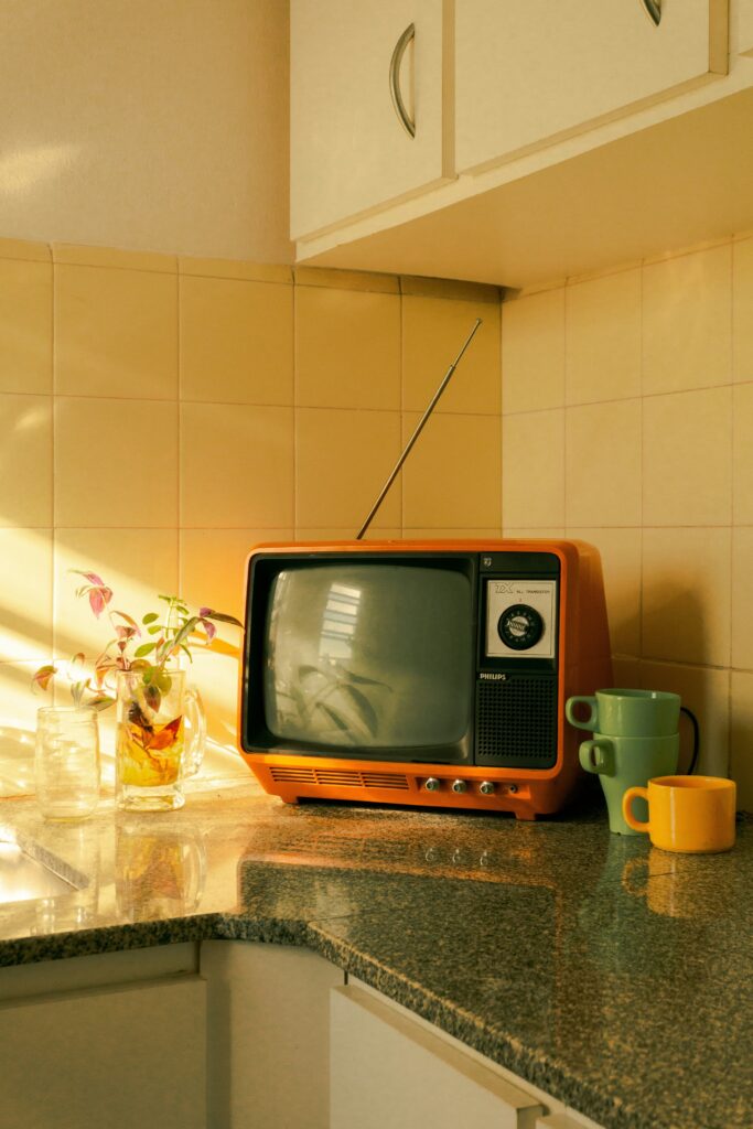 TV antiga em cozinha retrô, ilustrando artigo sobre como interditar um idoso e garantir sua proteção legal.