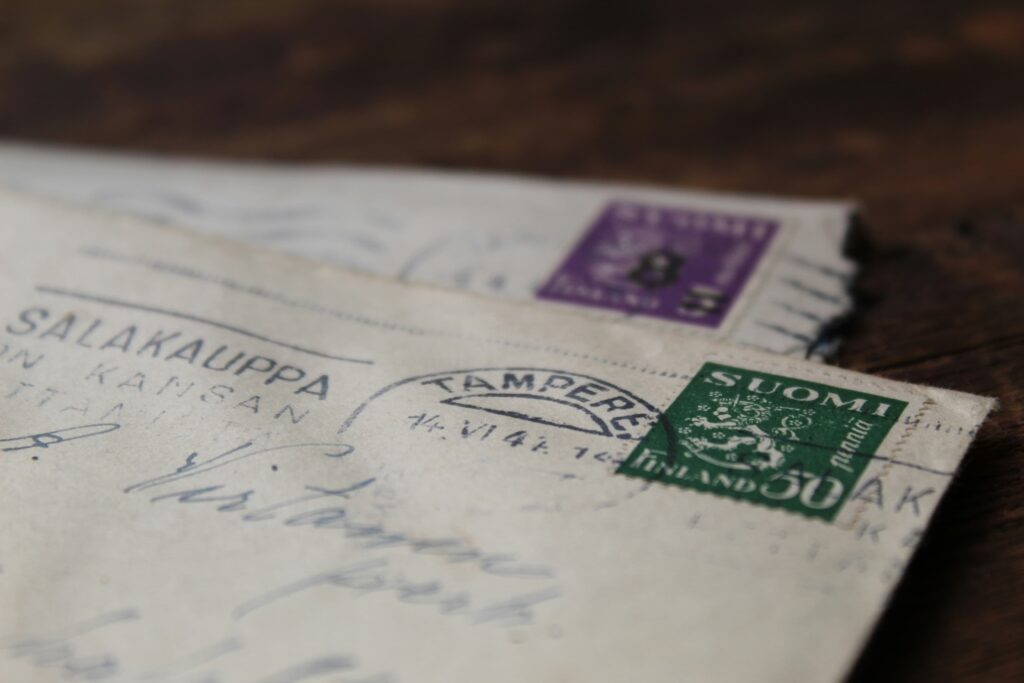 Envelopes antigos manuscritos com selos e carimbos postais, remetendo a documentos, história de vida e ao processo de interdição de um idoso.