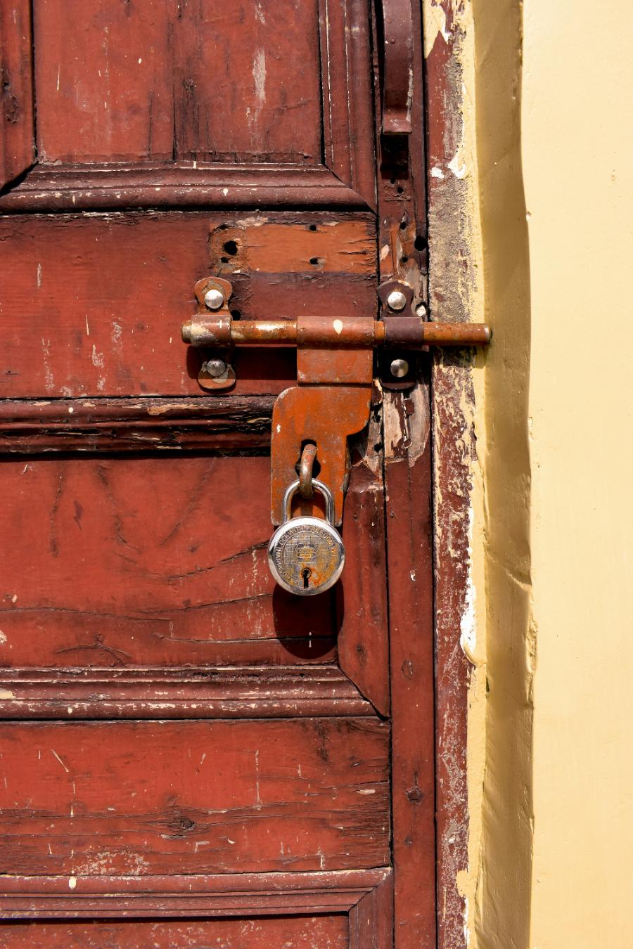 Porta de madeira com cadeado vintage, simbolizando a formalização da compra de imóvel