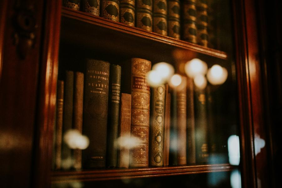 Livros de direito antigos em prateleira, remetendo ao processo judicial de interdição e curatela